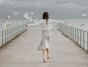 girl on dock with birds flying