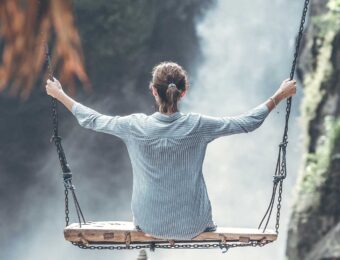 woman on a swing over a waterfall