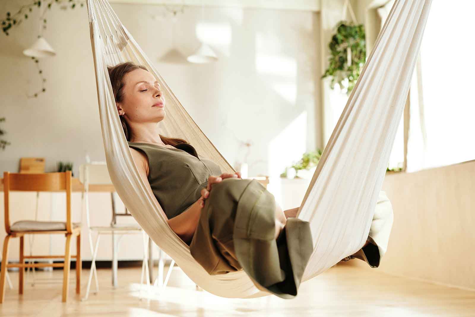 Woman relaxing in an indoor hammock